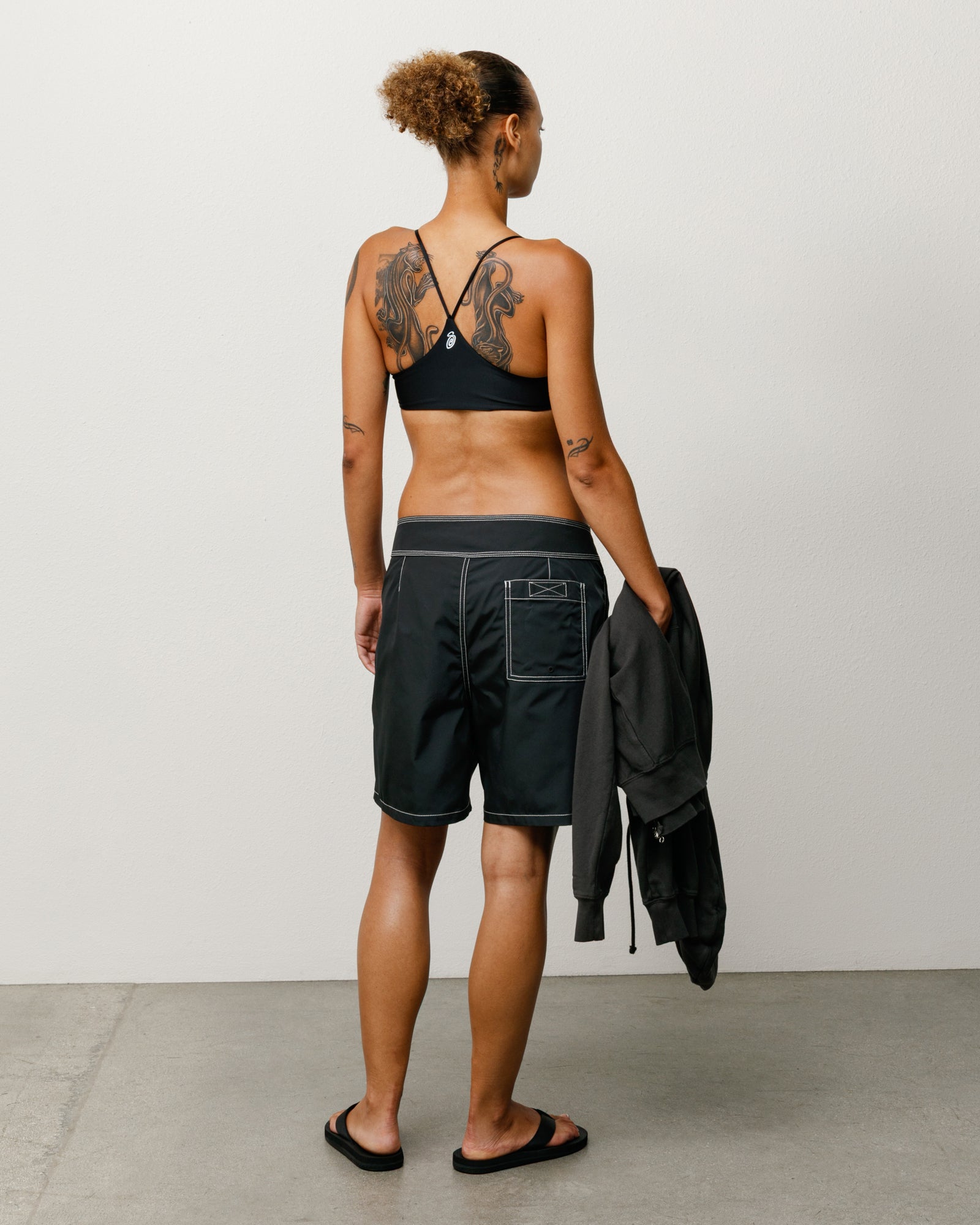 Coastal Board Short Unisex in Black, back view with white contrast stitching and patch pocket