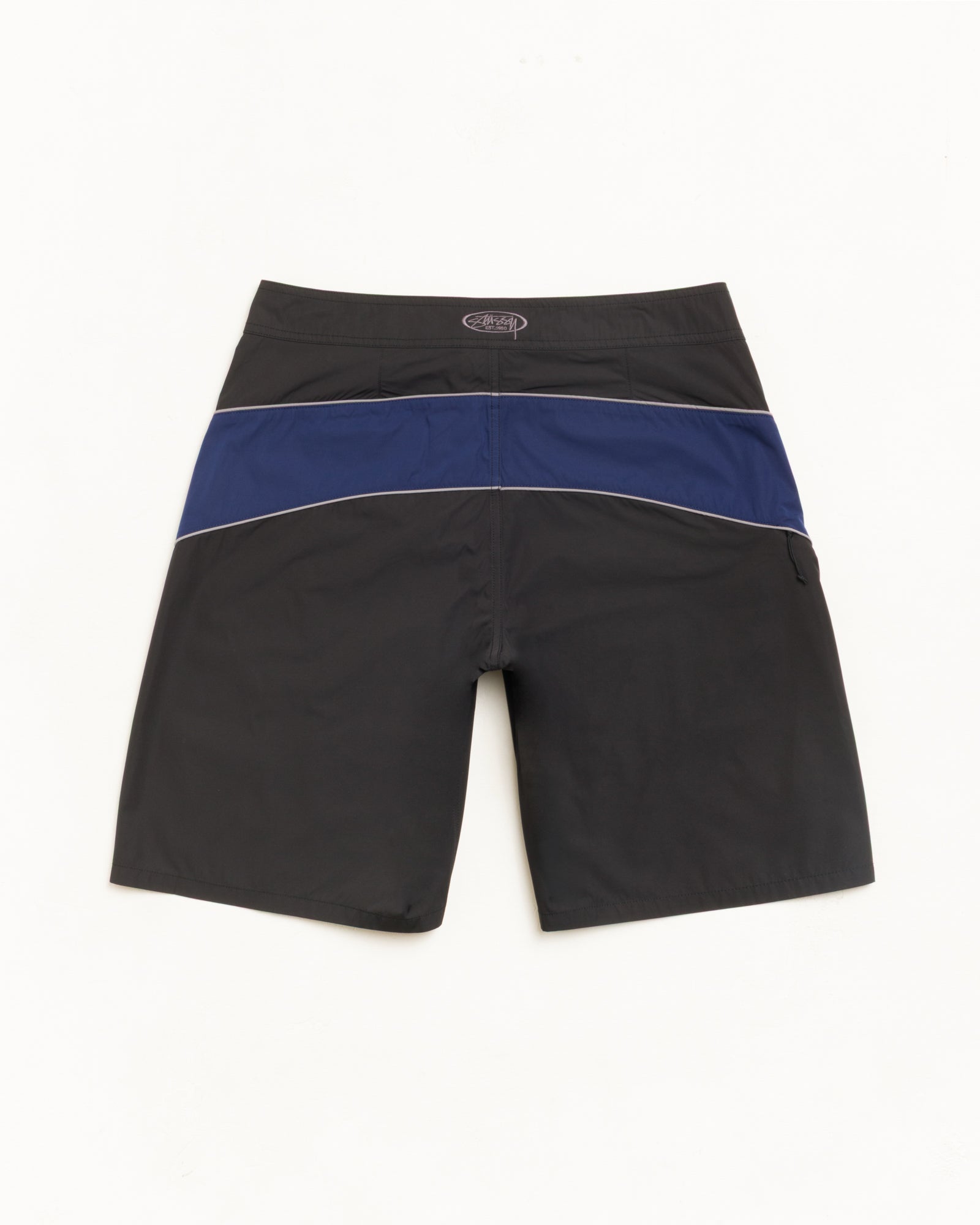 Cove Board Short bottoms in black with navy contrast band and piping, unisex relaxed fit.