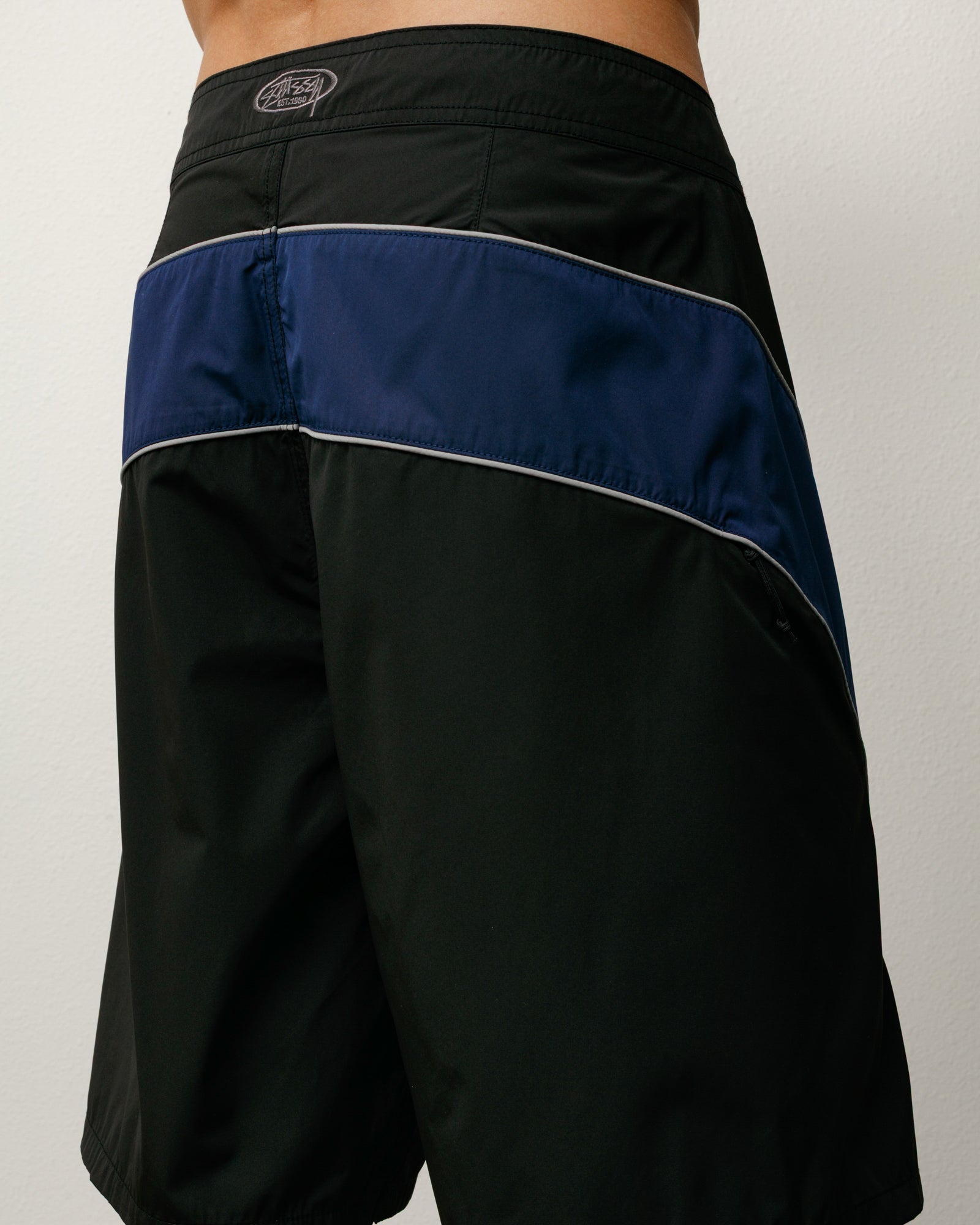 Cove Board Short boardshorts in black with navy contrast panel and Stüssy back waist embroidery.