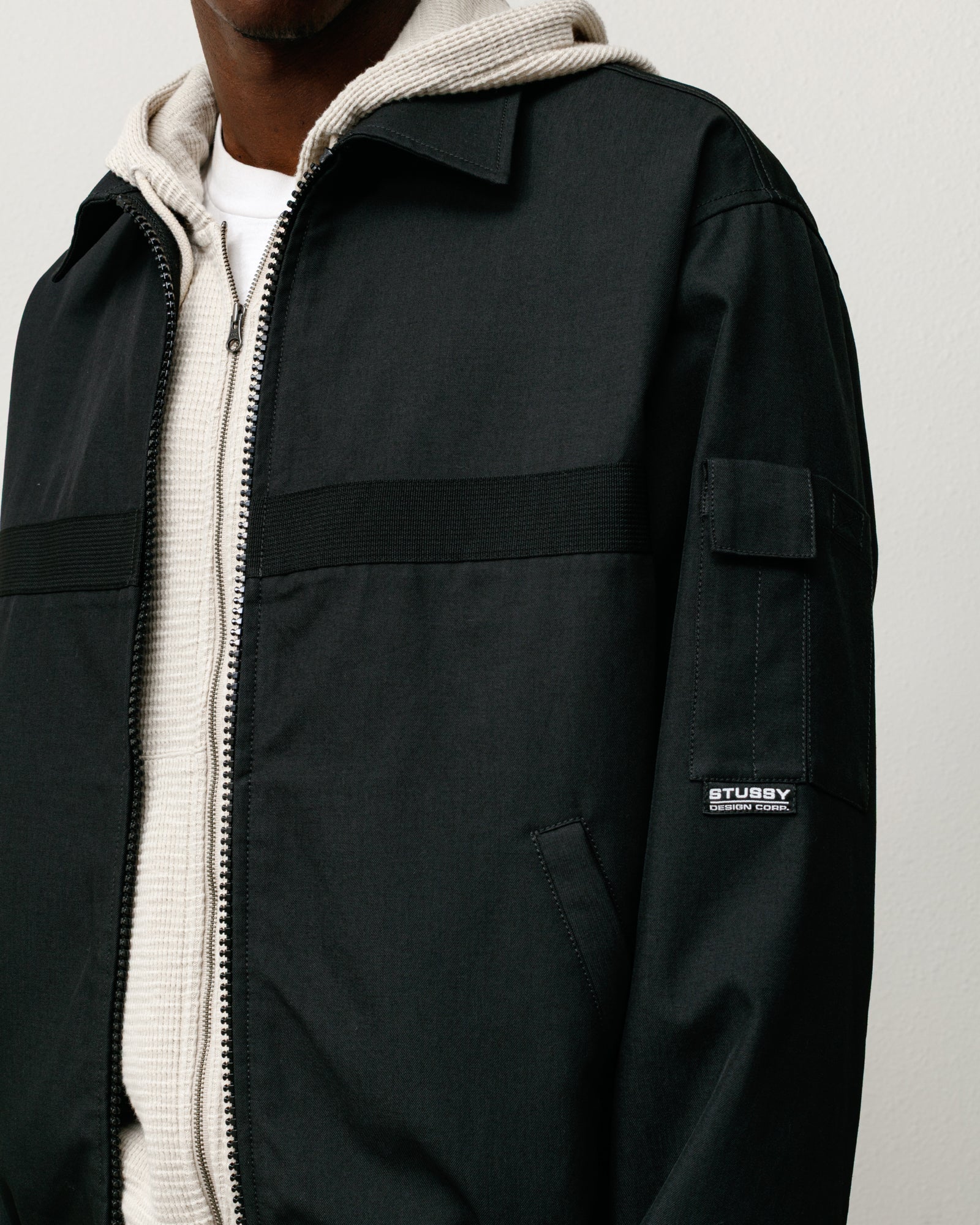 Mechanic Jacket in Black, zip-front design with welt pockets and sleeve patch label