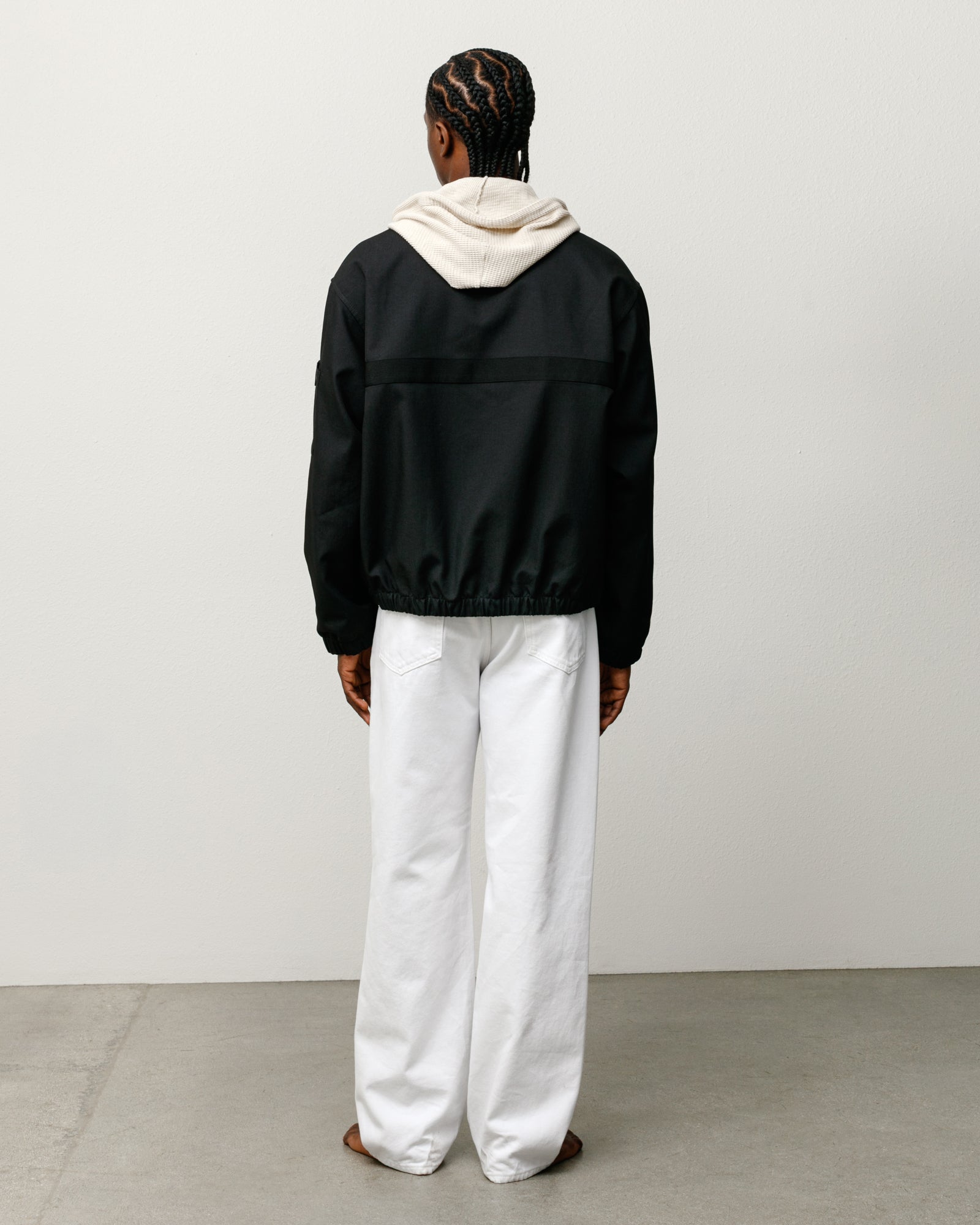 Mechanic Jacket in Black, back view with elastic hem and boxy fit, styled over a hoodie