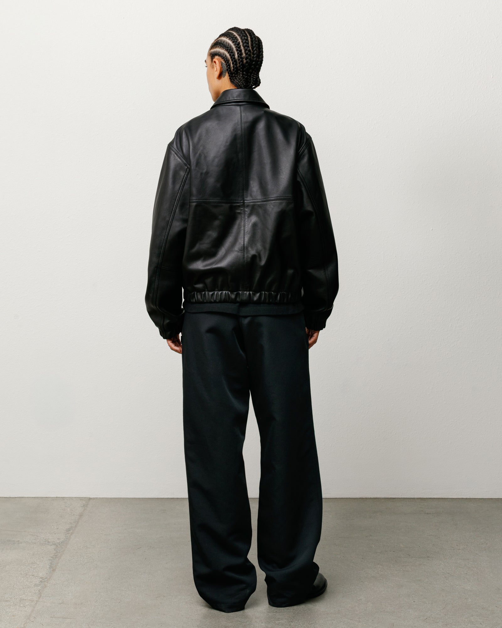 Leather Work Jacket in Black, back view on model with elastic hem and relaxed fit
