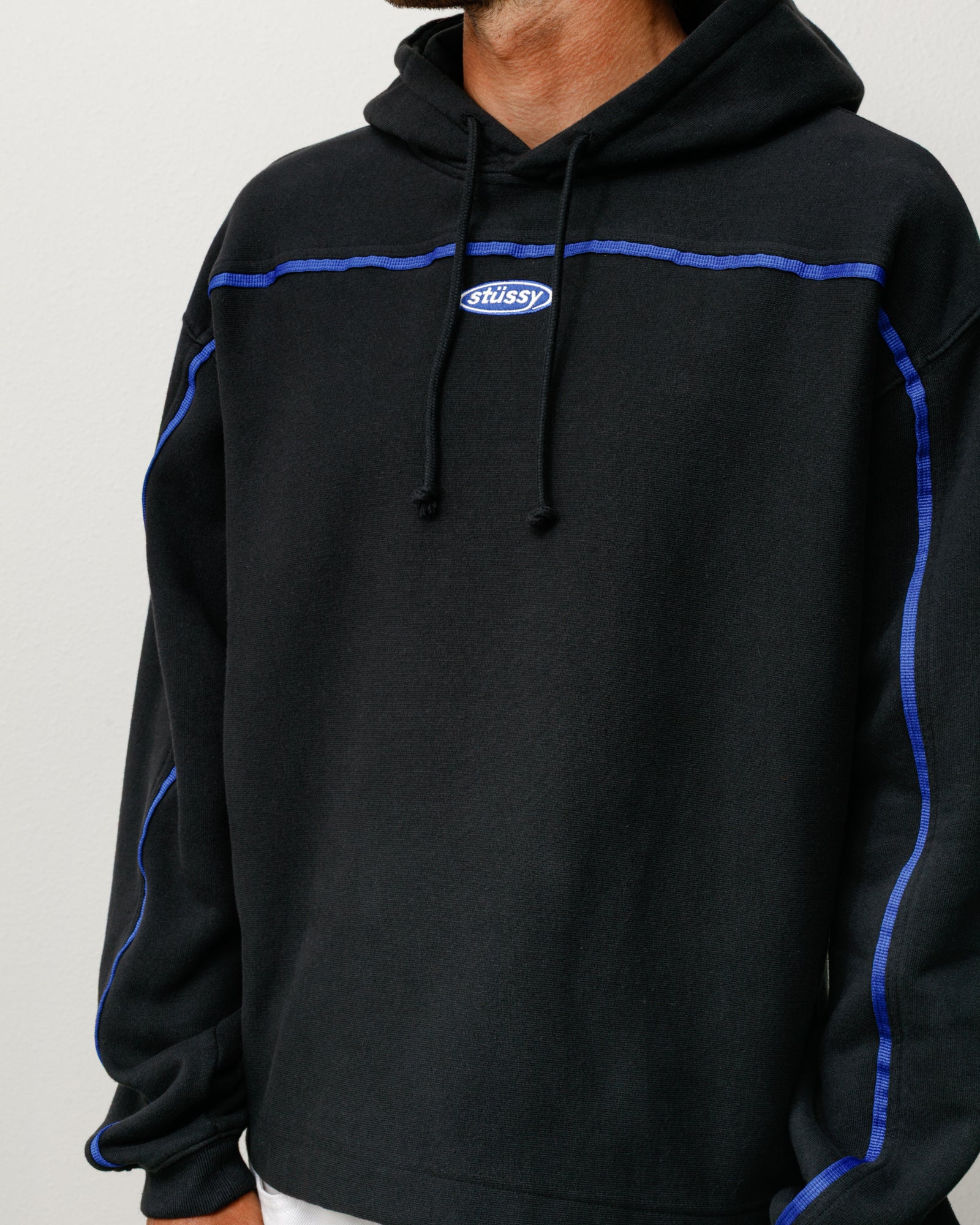 Stüssy Oval Pullover Hoodie in Black with blue contrast piping and a small chest logo
