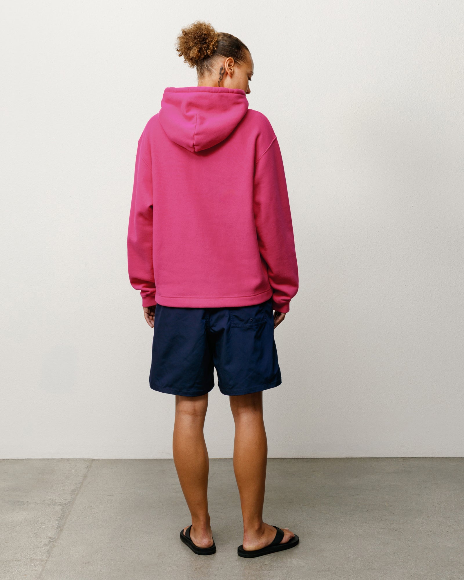 Oval Pullover Hoodie in Pink, back view on model with hood and ribbed hem.