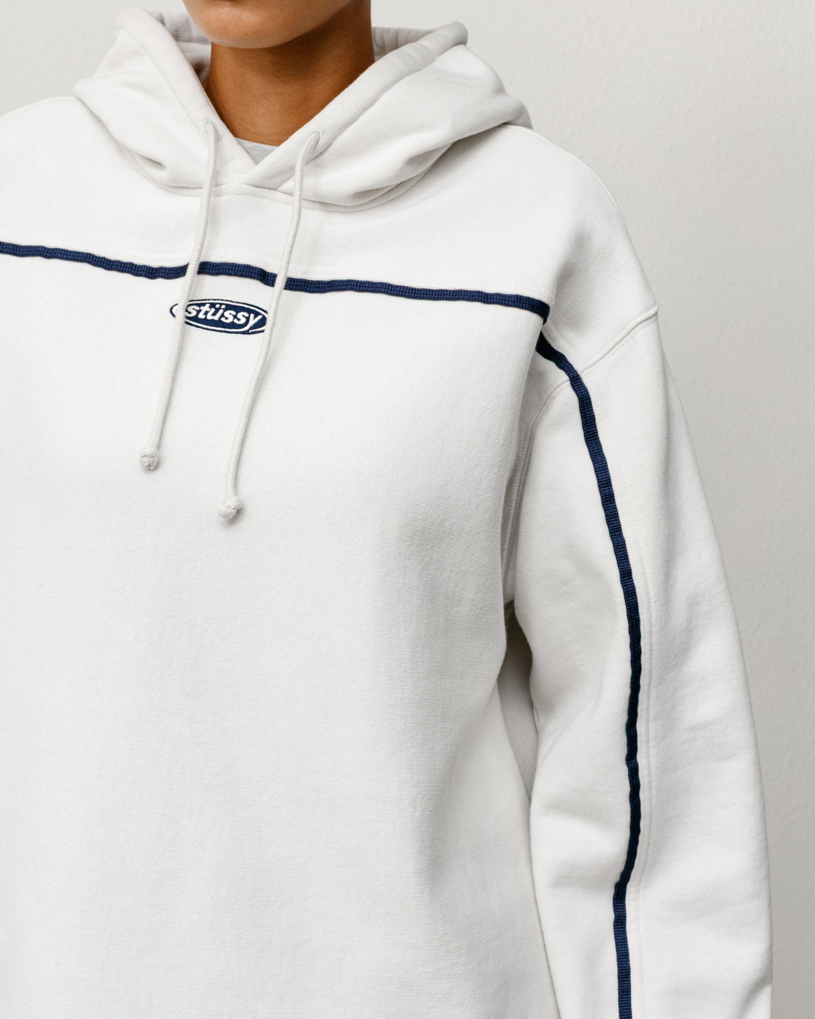 Oval Pullover Hoodie in Stone with navy chest piping and oval Stüssy logo embroidery