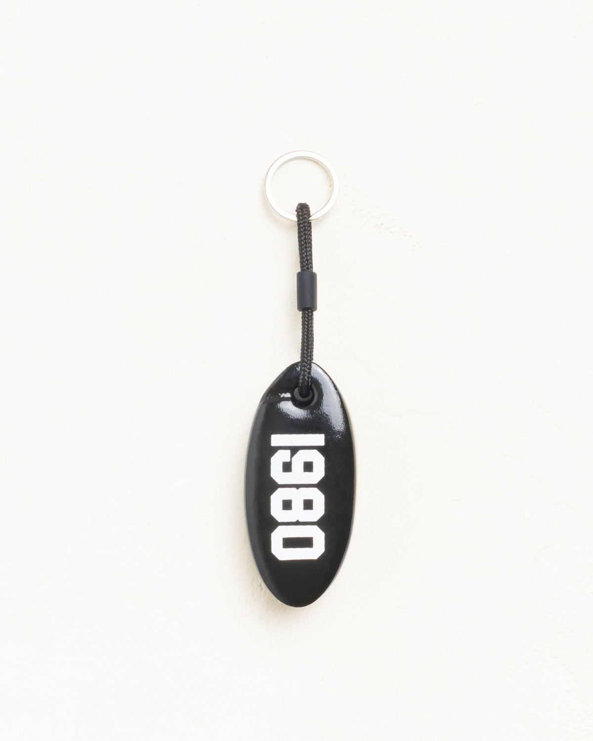Floatie Keychain accessory in black vinyl-coated foam with 1980 print