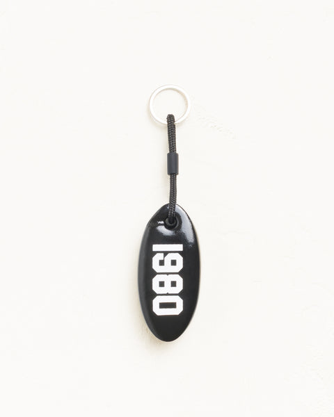 Floatie Keychain accessory in black vinyl-coated foam with 1980 print