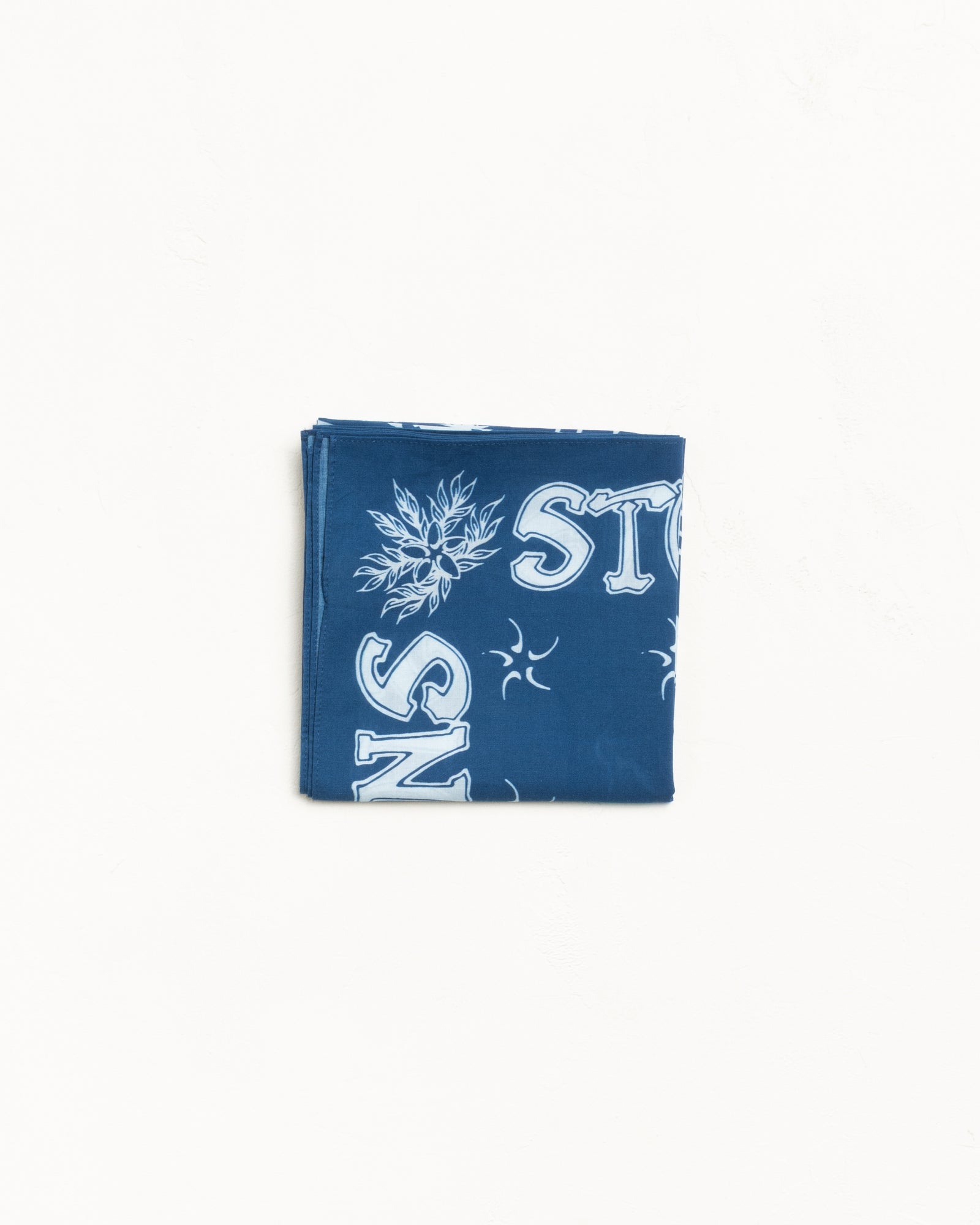 Surf Joker Bandana in Blue, folded blue bandana with white graphic print details