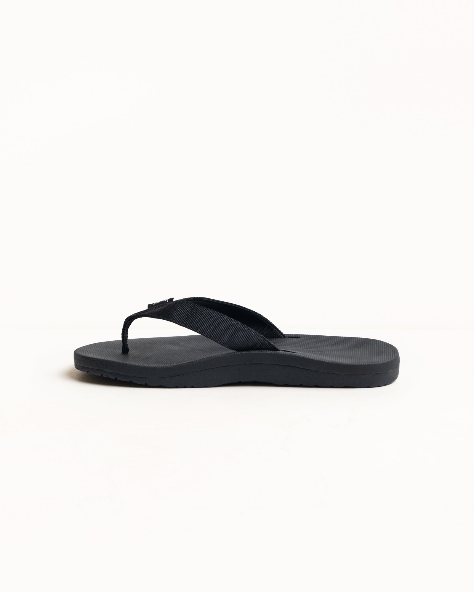 Rubber flip-flop in Black with wide nylon webbing strap and textured, contoured sole