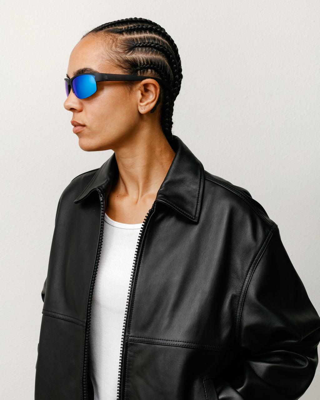 Model wearing the Hiro Sunglassesin Frost Black/Blue Mirror Lens with the Leather Work Jacket in Black.