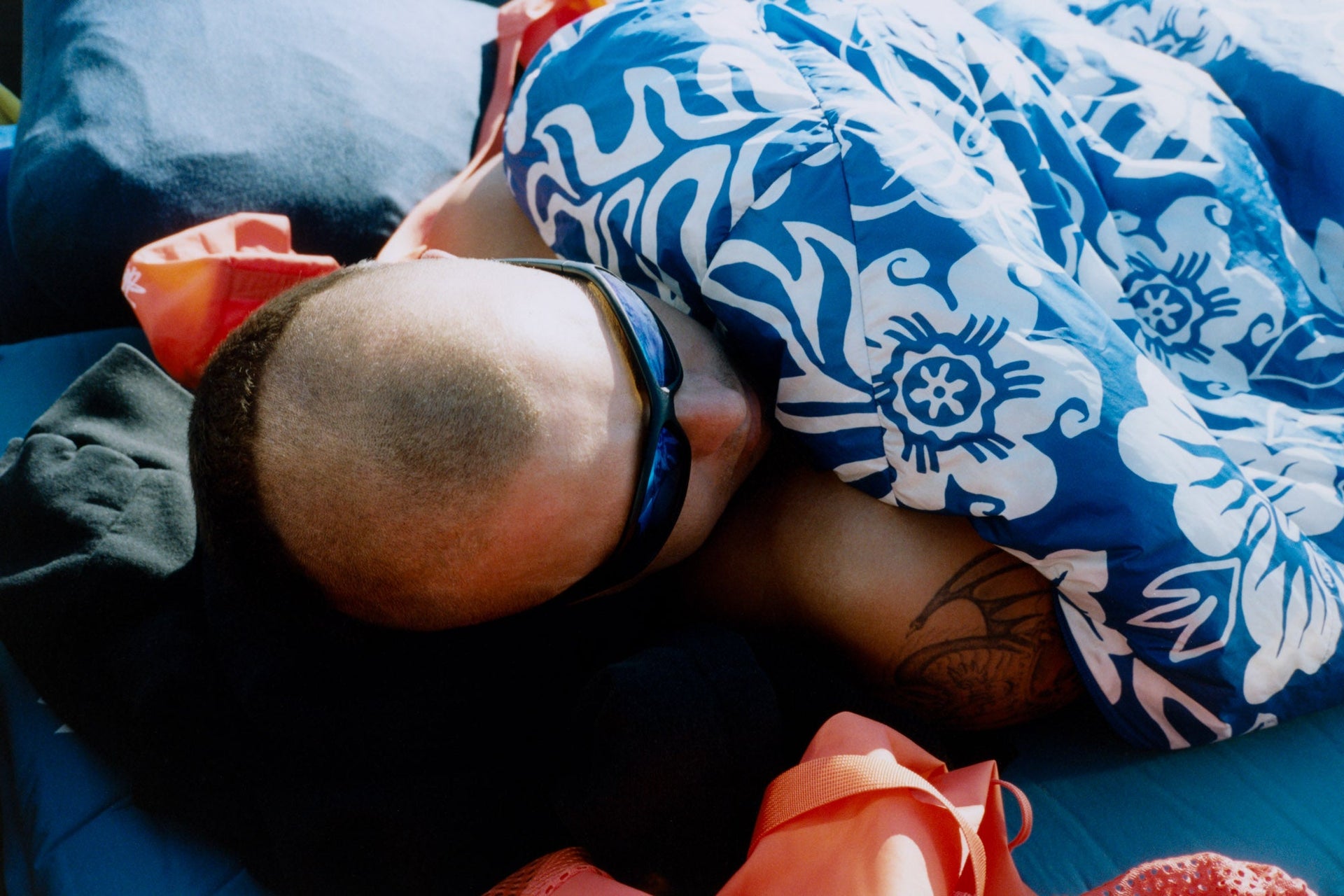 Stüssy & Mountain Hardwear Bishop Pass 30F Sleeping Bag with a person resting beneath the Wild Water Floral-print shell.